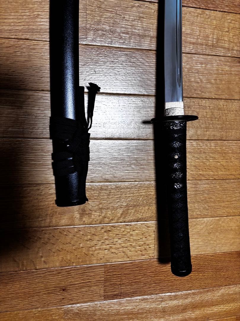 湾曲した刃の刀 黒い鞘と柄